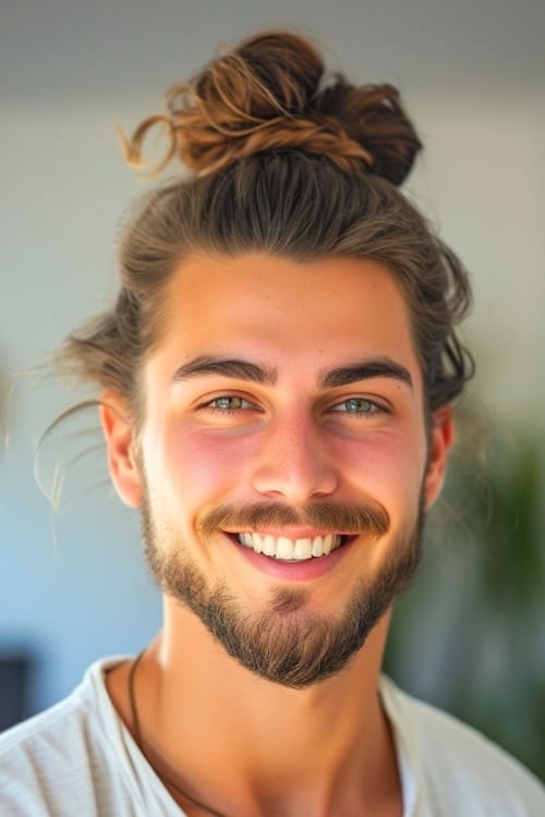 Penteado de nó superior de pão de homem no homem sorridente com barba.
