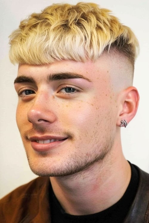 A pele loira desaparece o corte de cabelo masculino de Edgar.