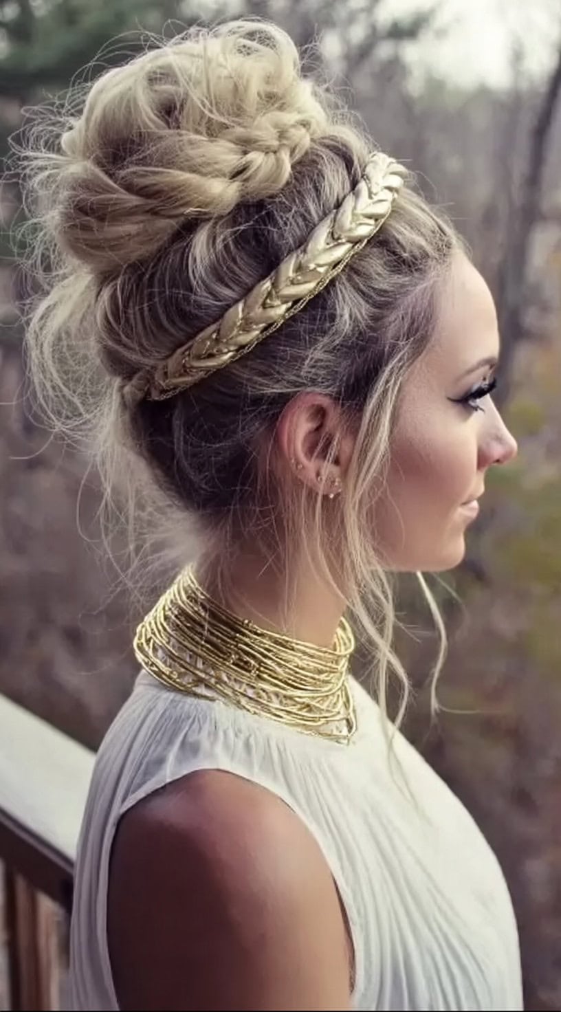 Perfil lateral de uma mulher com um pão trançado alto, fios soltos emoldurando o rosto e uma espessa faixa de cabeça no estilo de corda dourada.